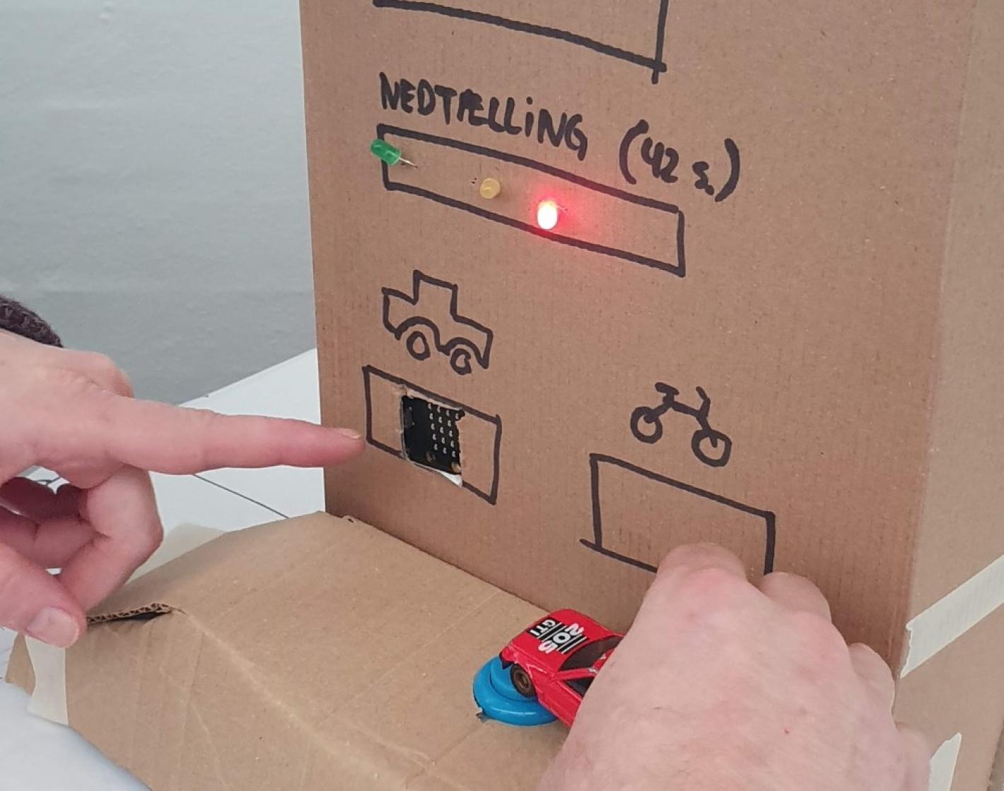 Afprøvning af elektronisk kredsløb med legetøjsbil og papkasse som måleaparat